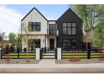 Striking two-tone modern farmhouse exterior with black trim, fenced yard, and manicured lawn at 1085 S Cook St, Denver, CO 80209