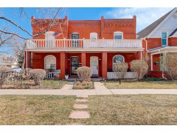 Charming red brick two-story home with a spacious front porch and manicured lawn at 404 S Grant St, Denver, CO 80209