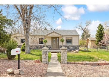 Charming single-story home with stone accents, a walkway and a well-manicured lawn at 25 Kendall St, Lakewood, CO 80226
