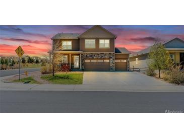 Beautiful two-story home featuring stone accents, well-manicured landscaping, and a three-car garage at 2177 Shadow Creek Dr, Castle Rock, CO 80104