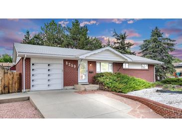 Charming brick home featuring a well-maintained front yard, attached garage and inviting entrance at 8259 Nola Dr, Denver, CO 80221