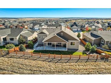 Expansive backyard and covered patio area perfect for outdoor entertaining in a suburban neighborhood at 6673 Mentha Dr, Castle Rock, CO 80108