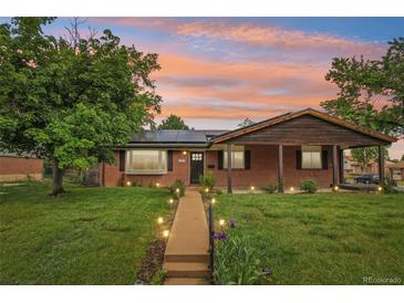 Charming red brick home featuring a well-manicured lawn and inviting walkway at sunset at 4293 Graham Ct, Boulder, CO 80305