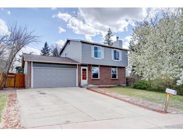 Charming two-story home with a well-manicured lawn and a detached two-car garage at 17912 E Milan Pl, Aurora, CO 80013
