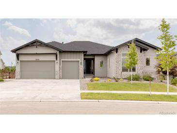Charming single Gathering home showcasing a well-manicured lawn, stone accents, and a three-car garage at 6608 S White Crow Ct, Aurora, CO 80016