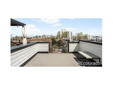 Relax on this rooftop deck with panoramic city views, offering a perfect spot for entertaining and enjoying the outdoors at 3520 W Connejos Pl # 5, Denver, CO 80204