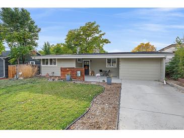 Charming one-story home boasts a well-manicured lawn and inviting front porch with seating at 7911 Raleigh Pl, Westminster, CO 80030