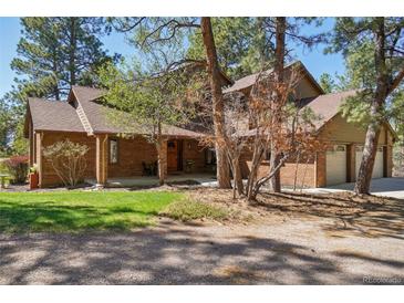 Charming brick home featuring mature trees, covered entry and an attached two car garage, perfect for mountain living at 1332 Meadow Trl, Franktown, CO 80116