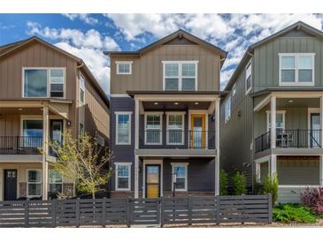 Charming two-story home with a yellow door and a cozy front porch with black metal railing at 8953 Southurst St, Littleton, CO 80129