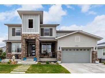 Charming two-story home with a stone facade, covered porch and manicured lawn at 5964 E 141St Ave, Thornton, CO 80602