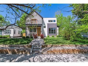Modern two-story home boasts professional landscaping, a stone facade, and a contemporary design at 1911 S Lafayette St, Denver, CO 80210