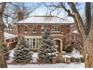Charming brick home featuring a manicured front yard, mature trees, and a classic architectural design at 425 Monroe St, Denver, CO 80206