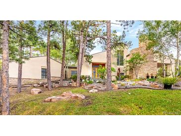 Contemporary home featuring unique design elements, rock landscaping and mature trees at 1250 Dolan Dr, Monument, CO 80132