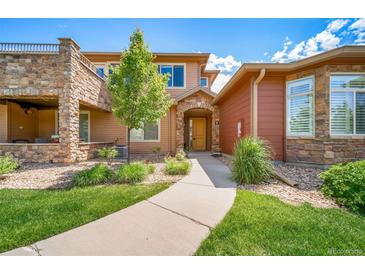 Inviting two-story home with a well-manicured front yard and stone accents at 8626 Gold Peak Dr # B, Highlands Ranch, CO 80130