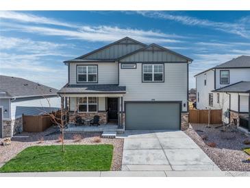 Two-story home with a two-car garage, covered front porch, and a well-maintained lawn against a bright sky at 490 Silver Rock Trl, Castle Rock, CO 80104