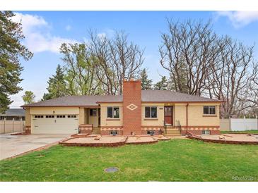 Charming ranch-style home featuring a brick chimney and attached two-car garage at 60 Yarrow St, Lakewood, CO 80226