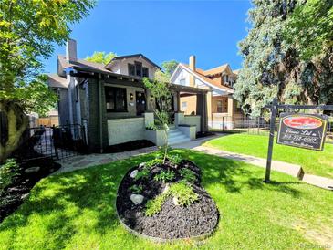 Charming two-story home with a well-manicured lawn, landscaping, and a real estate sign at 2725 N Gaylord St, Denver, CO 80205