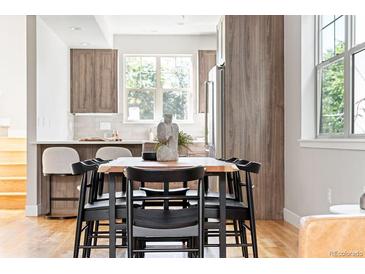 Open dining area with a wood table, black chairs, and modern decor near the kitchen at 2828 N Federal Blvd, Denver, CO 80211