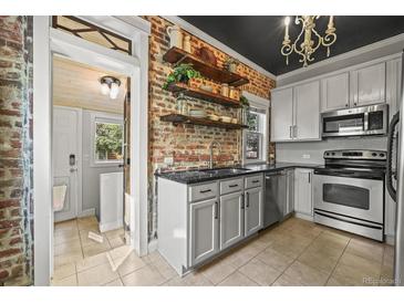 Charming kitchen features exposed brick, open shelving, modern appliances, and updated countertops at 1024 34Th St, Denver, CO 80205