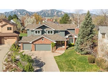 Charming home with brick accents, a three-car garage, mature trees and mountain views at 1437 Cassin Ct, Boulder, CO 80303