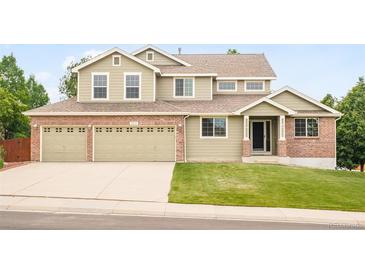 Charming two-story home with a brick and siding exterior and a spacious three-car garage at 1477 Serene Dr, Erie, CO 80516