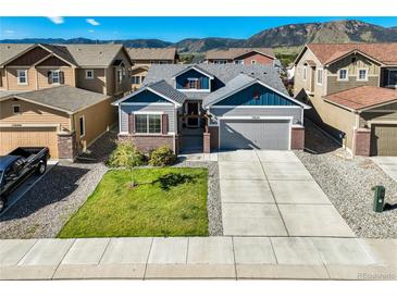 Charming two-story home with a well-manicured lawn, driveway, and mountain views in the background at 17620 Leisure Lake Dr, Monument, CO 80132