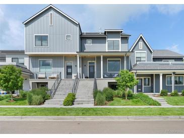 Stylish modern townhomes with well-manicured lawns, gray siding, and inviting front entrances at 385 East St, Louisville, CO 80027