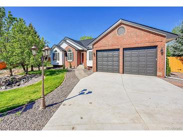 Charming two-story brick home with a well-maintained lawn and a two-car garage at 7809 S Flower St, Littleton, CO 80128