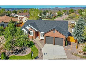 Attractive two-story brick and white home with a well-manicured lawn and a convenient two-car garage at 7809 S Flower St, Littleton, CO 80128