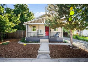 Charming single-story home with a cozy front porch and inviting curb appeal with lawn and walkway at 4955 Julian St, Denver, CO 80221