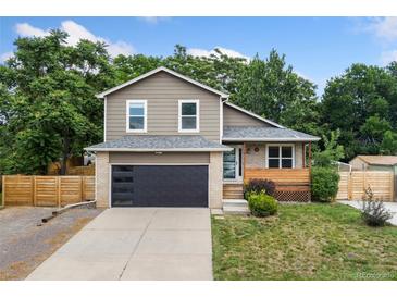 Charming two-story home featuring a modern garage door and cozy front porch at 7120 S Clay St, Littleton, CO 80120