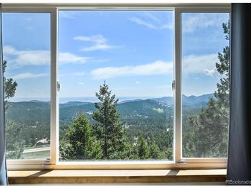 Wonderful mountain views are shown through an oversized window at 8386 S Davco Dr, Morrison, CO 80465