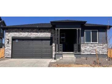 Charming single-story home with a stone-accented facade and an attached two-car garage at 6077 Caribou Dr, Brighton, CO 80601