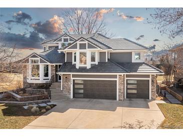 Stunning two-story home with a meticulously kept lawn, gray exterior, stone accents, and a three-car garage at 538 Fairfield Ln, Louisville, CO 80027