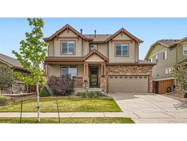 Inviting two-story home with a stone facade, covered porch, and well-maintained lawn at 350 N Langdale Ct, Aurora, CO 80018