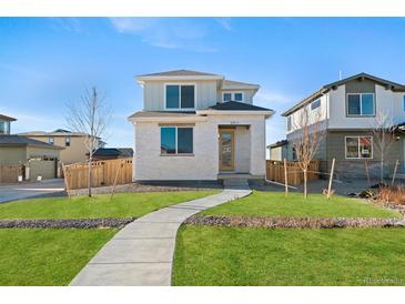 Charming two-story home featuring a well-manicured lawn and inviting walkway at 21134 E 63Rd Dr, Aurora, CO 80019