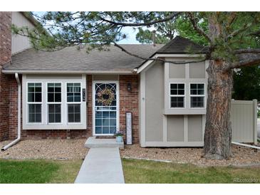 Charming home featuring brick and siding exterior, lovely front yard, and welcoming front door at 9713 W Chatfield Ave # H, Littleton, CO 80128