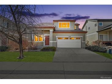 Charming two-story home with a two-car garage and well-manicured lawn at dusk at 2520 E 127Th Ave, Thornton, CO 80241