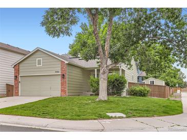 Charming single-Gathering home featuring a lush front yard with mature trees and an attached two-car garage at 9705 Autumnwood Pl, Highlands Ranch, CO 80129