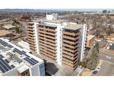 A multi-story building with a balcony on each floor and views of a city skyline and mountains in the background at 4570 E Yale Ave # 507, Denver, CO 80222