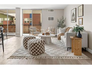 Bright living room featuring a modern sofa, stylish rug, and balcony access for indoor/outdoor living at 4570 E Yale Ave # 507, Denver, CO 80222