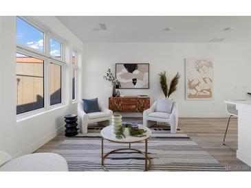 Bright living room featuring modern furnishings, stylish decor, and large windows at 6971 E Lowry Blvd, Denver, CO 80230
