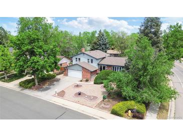 Charming two-story home with lush landscaping, a brick facade, and an attached two-car garage at 1590 S Macon St, Aurora, CO 80012