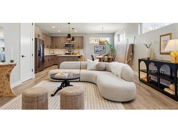 Open-concept living room featuring modern furnishings and seamless flow to the updated kitchen and dining area at 4125 Tejon St, Denver, CO 80211