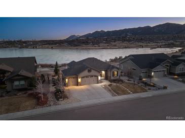 Aerial view of a charming house with mountain views, a three-car garage, and a landscaped front yard at 2891 Waterfront Dr, Monument, CO 80132