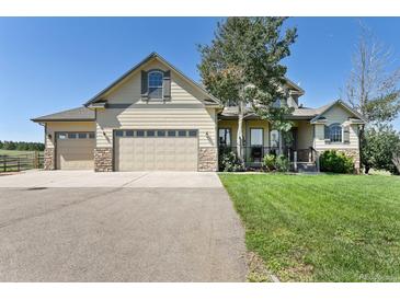 Lovely two-story home with a three-car garage, stone accents, and well-manicured lawn at 2550 Gold Creek Dr, Elizabeth, CO 80107