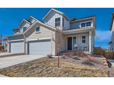 Charming two-story home with a two-car garage and inviting front porch with rocking chairs at 147 Silver Rock Trl, Castle Rock, CO 80104