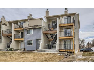 View of townhome complex featuring siding, black iron balconies and stairs to the upper units at 6009 Yarrow St # B, Arvada, CO 80004