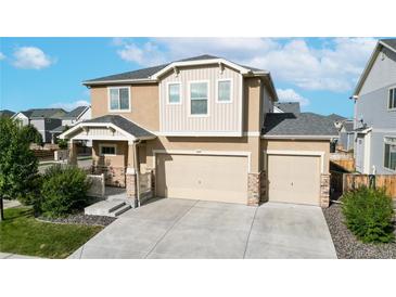 Inviting two-story home showcasing a three-car garage and well-maintained landscaping at 10109 Yampa St, Commerce City, CO 80022