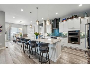 Spacious open-concept kitchen with granite countertops, oversized island, and stainless steel appliances at 6469 Barnstead Dr, Castle Pines, CO 80108